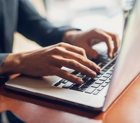 a person using a laptop computer sitting on top of a table