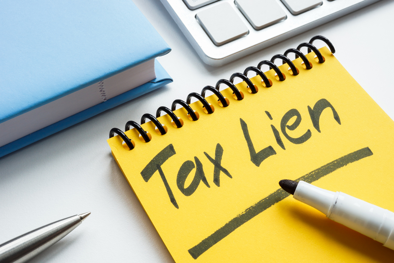 Image of a yellow spiral notepad with “Tax Lien” written boldly in marker and underlined. Image of a yellow spiral notepad with “Tax Lien” written boldly in marker and underlined.