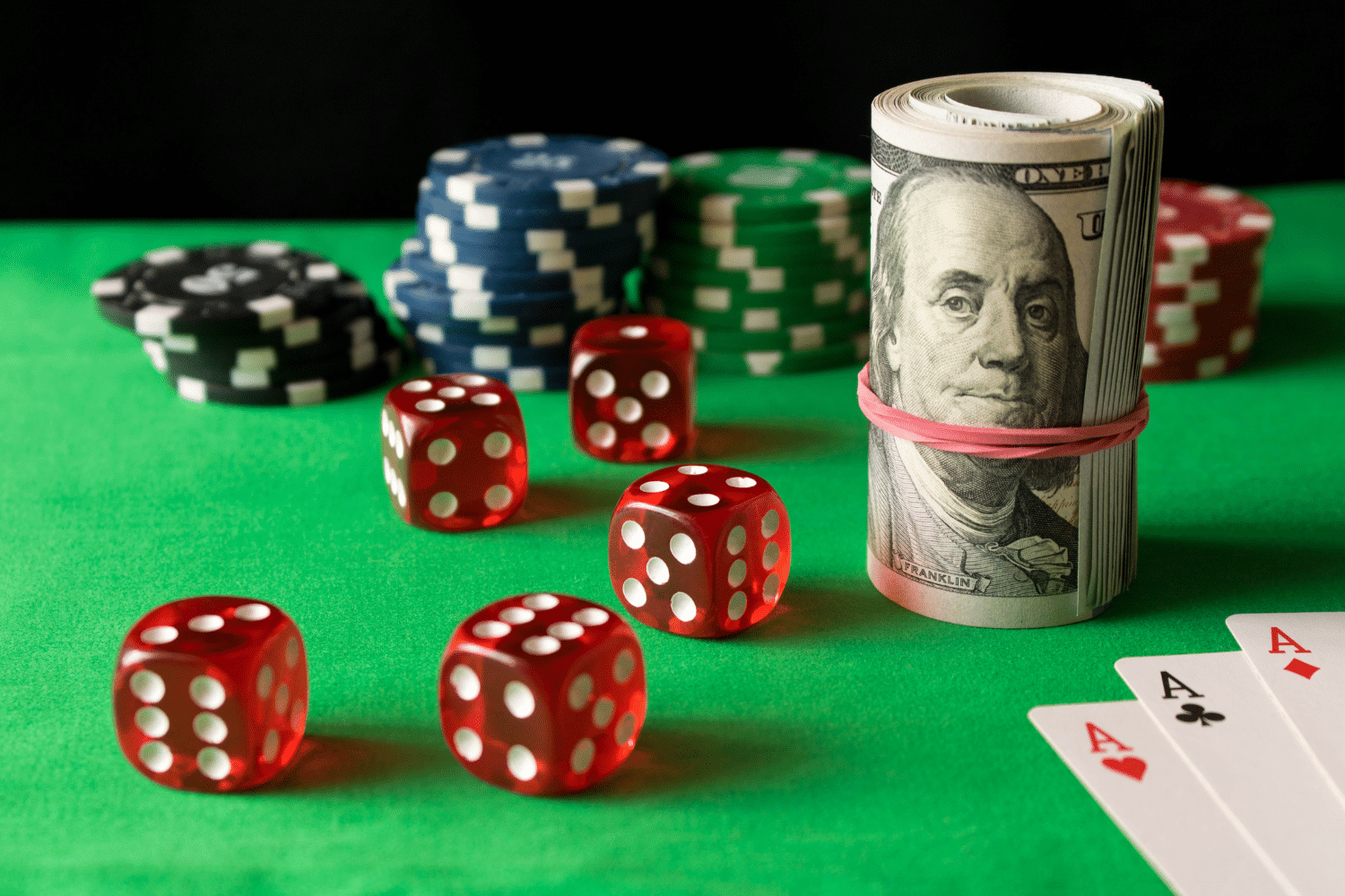 Poker chips, dice, and a roll of 100-dollar bills, representing the new tax law & gambling losses