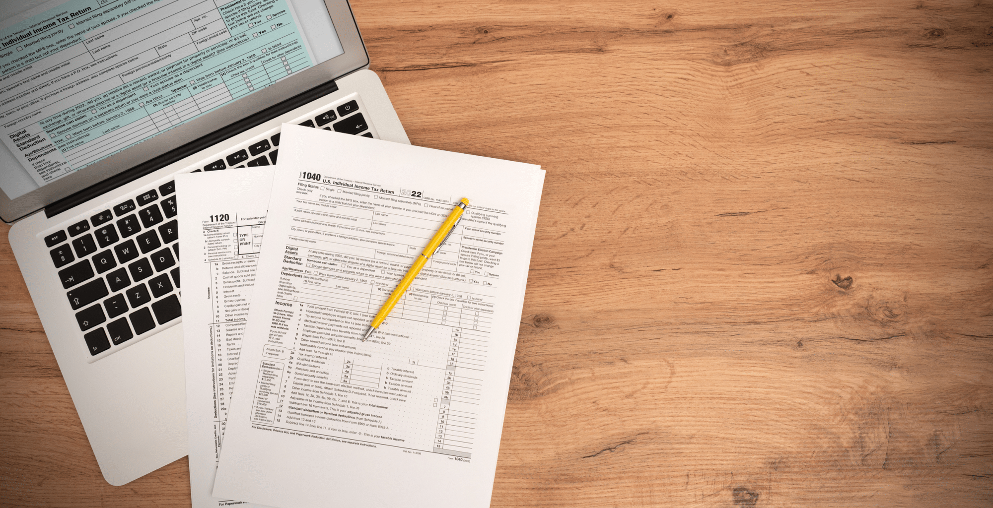 U.S. individual tax return papers and a laptop on top of a desk