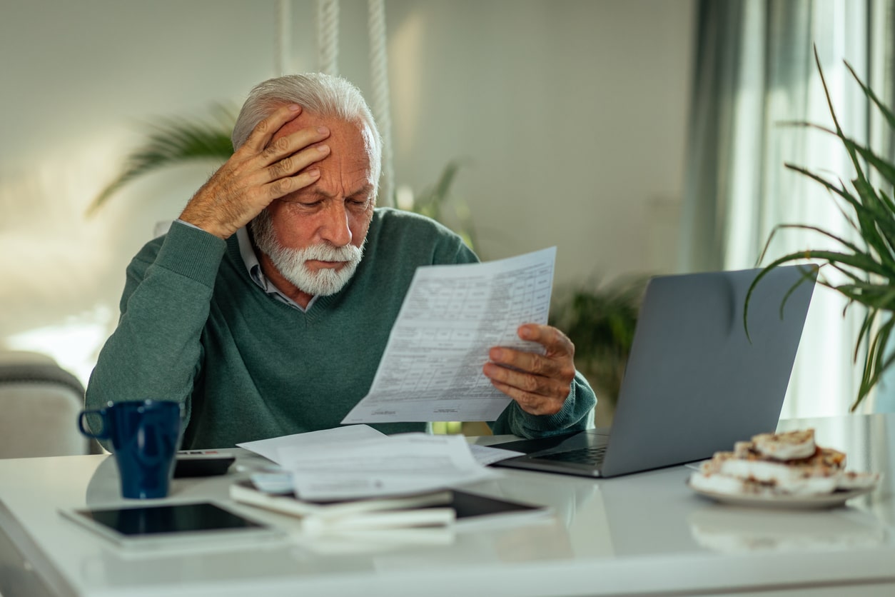An overwhelmed man reviews a demand for payment letter from the Indiana DOR at his desk
