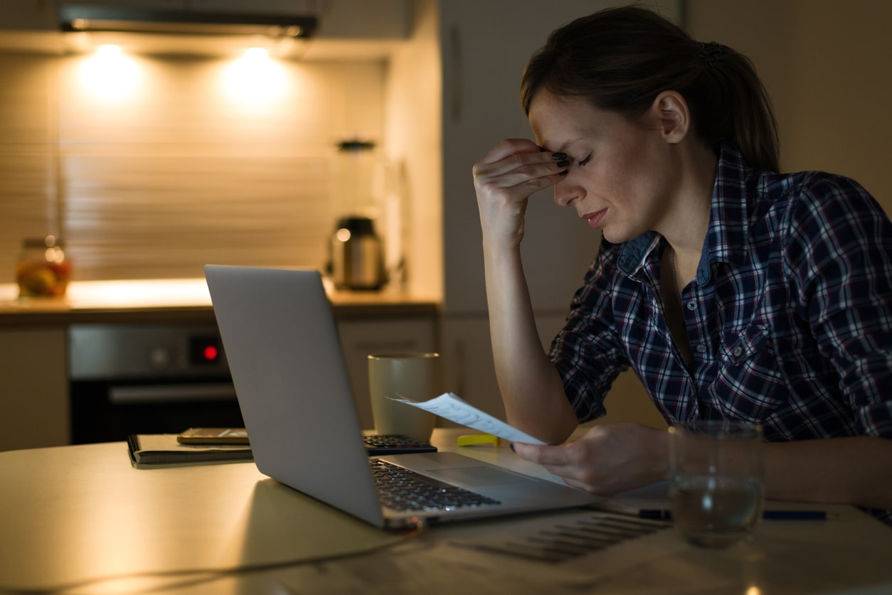 A woman stressed at her computer, wondering what happens if you can’t pay your taxes